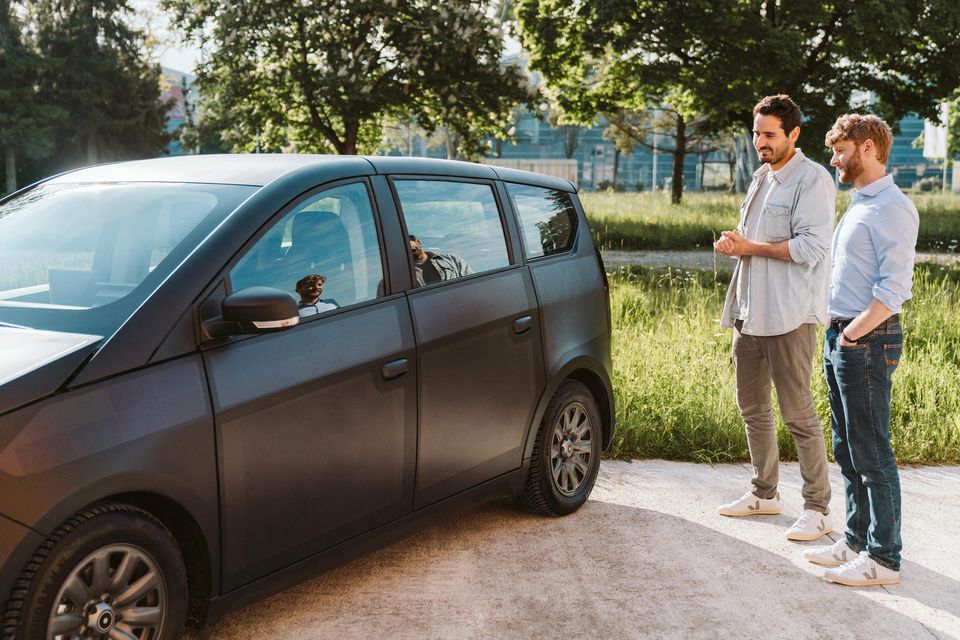 Laurin Hahn (l.) und Jona Christians stehen neben einem Solarauto von Sono Motors