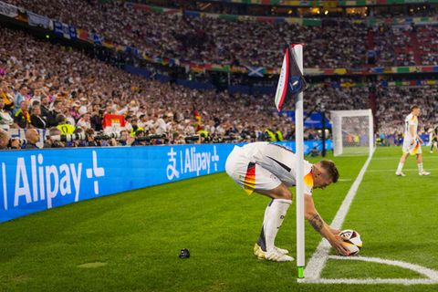 Nationalspieler Toni Kroos beim Eckball, im Hintergrund das Logo des chinesischen Zahlungsdienstleisters Alipay+