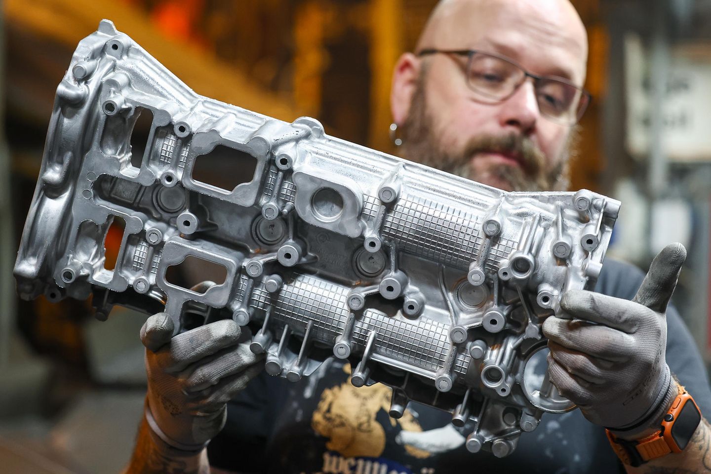 Ein Mitarbeiter der Handtmann Leichtmetallgießerei Annaberg prüft ein Aluminium-Gußteil nach dem Guß