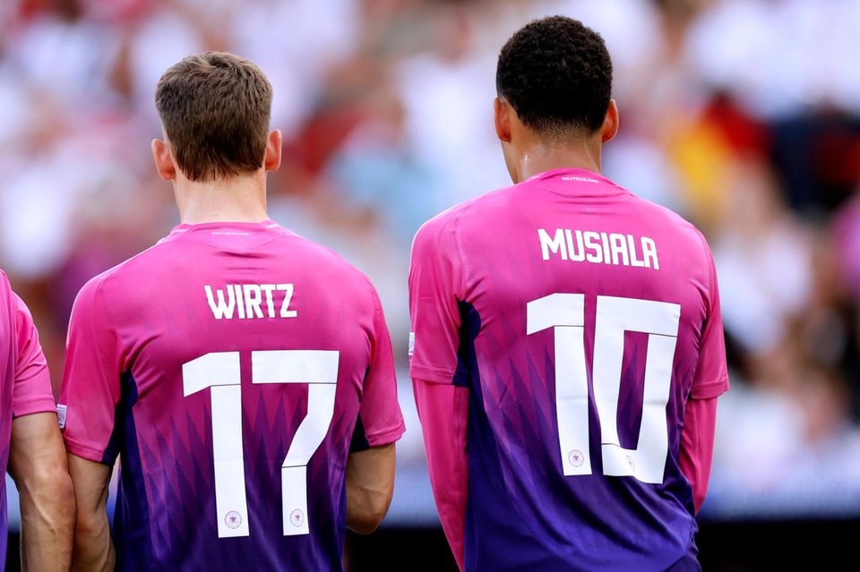 Florian Wirtz und Jamal Musiala stehen in einer Freistoßmauer