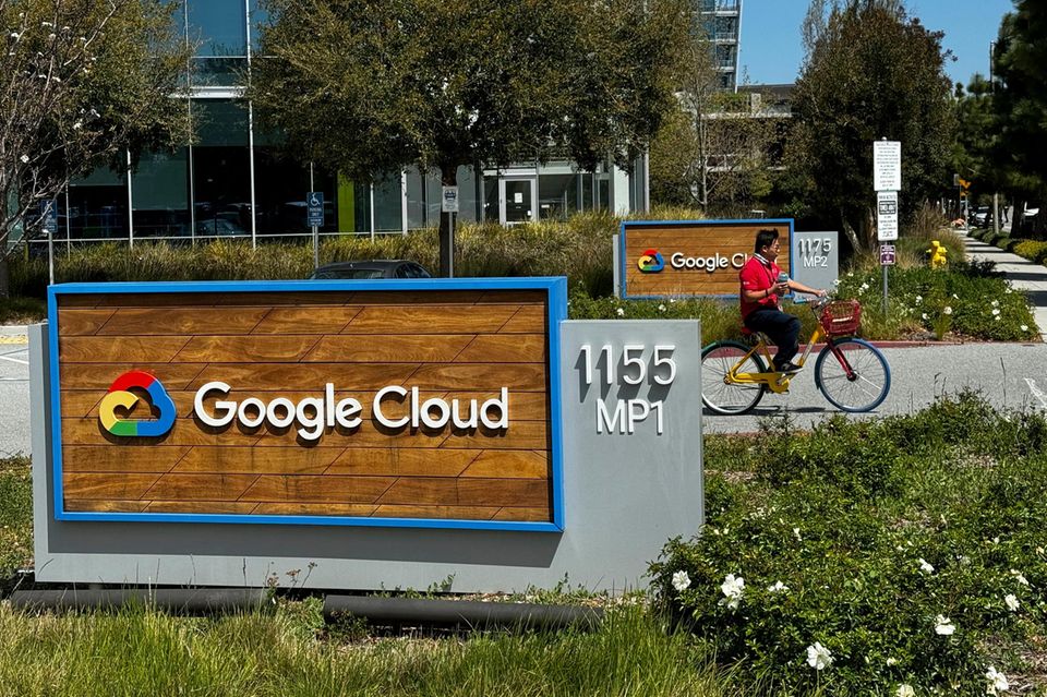 Eine Person fährt an einem Google-Schild vor den Firmengebäuden von Google in Sunnyvale vorbei