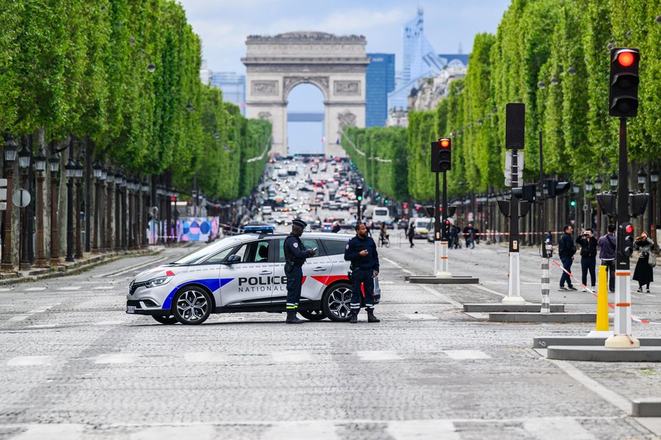 Polizisten auf dem Place de la Concorde. Die Champs-Elysee mit dem Arc de Triomphe im Hintergrund ist teilweise gesperrt