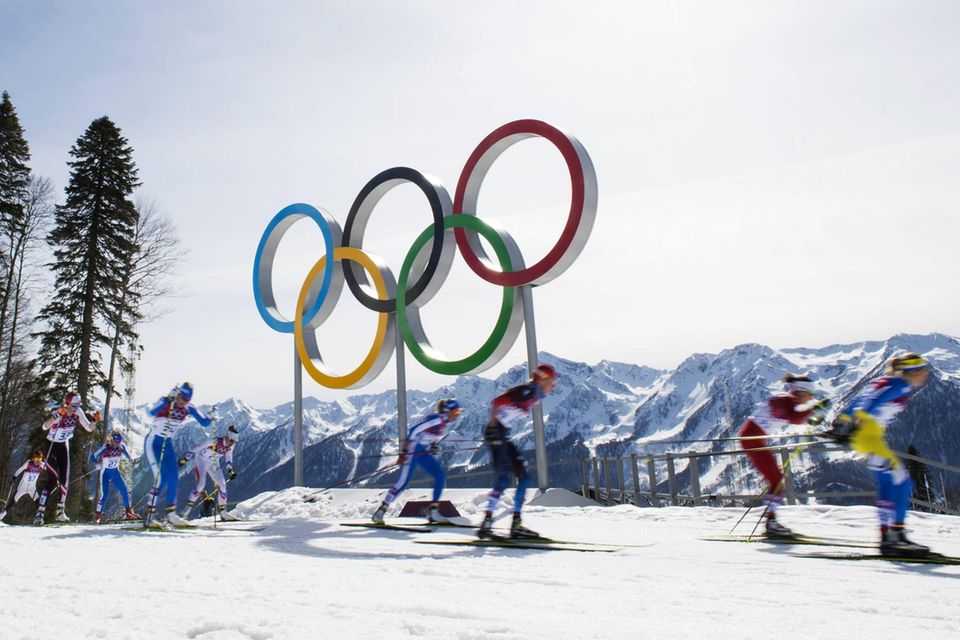 Langläufer bei den Spielen in Sotschi laufen an den Olympischen Ringen vorbei
