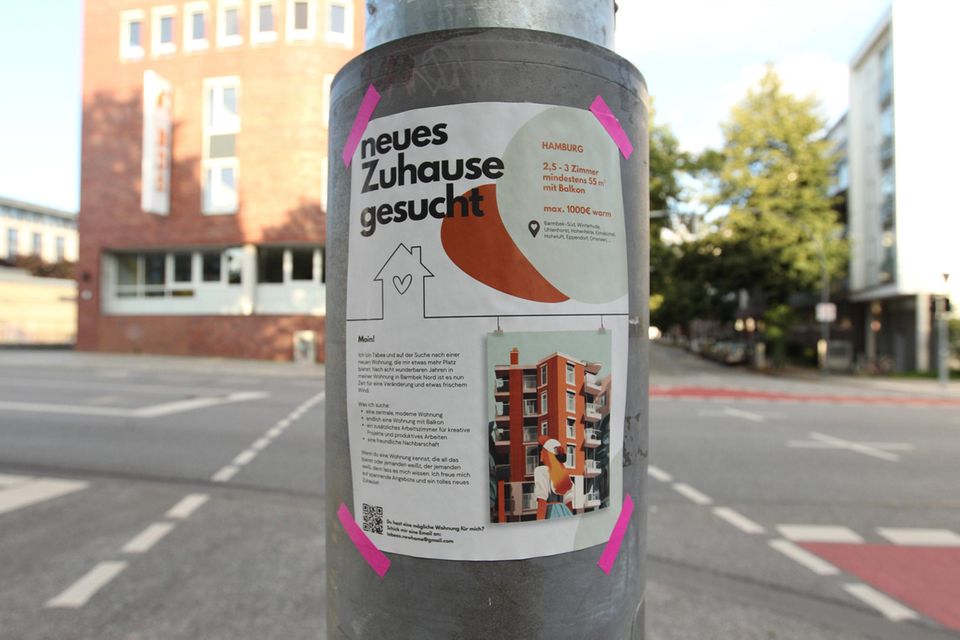 An einem Laternenpfahl klebt ein Zettel mit dem Wohnungsgesuch einer Frau, die eine Wohnung in Hamburg sucht
