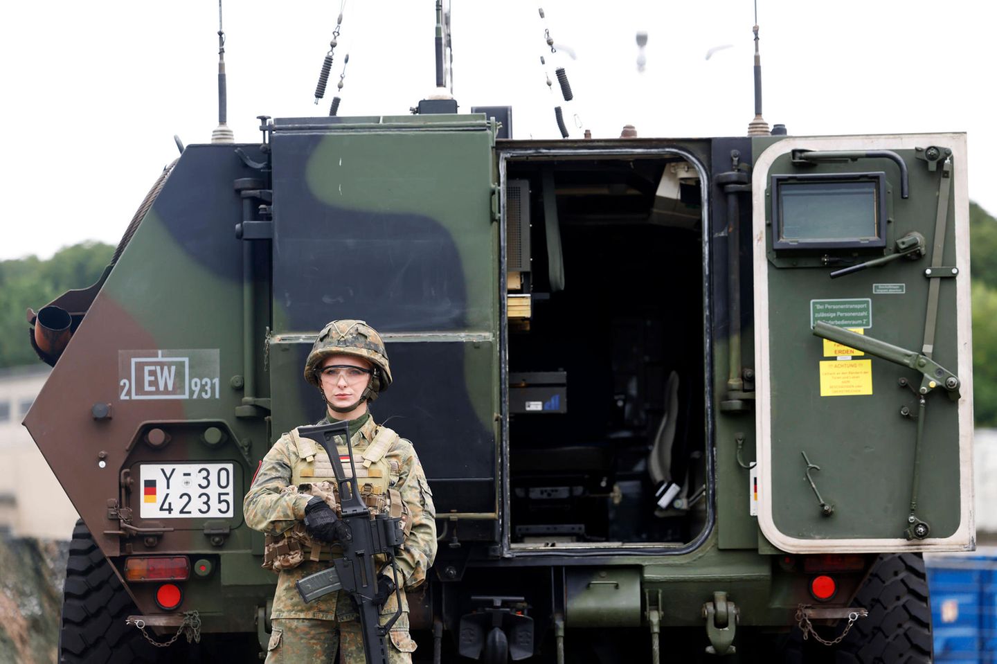 Eine Soldatin mit G36 Gewehr steht vor einem Bundeswehr-Fahrzeug