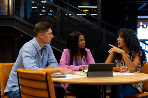 Mitarbeiter sitzen an einem Tisch und unterhalten sich