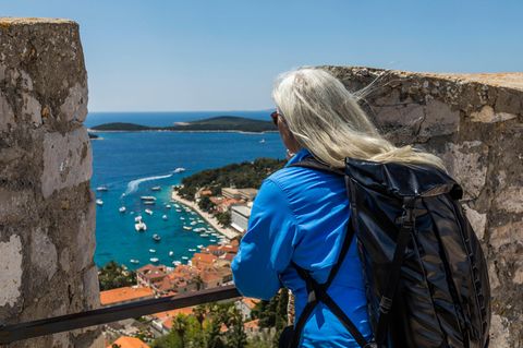 Ältere Frau blickt auf die kroatische Hafenstadt Hvar