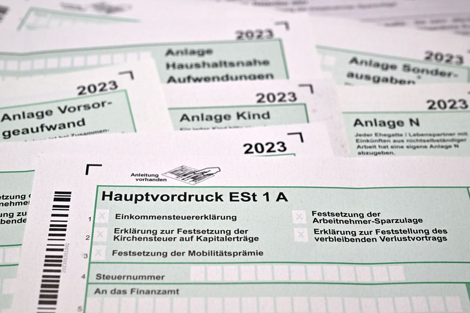 Formulare für die Einkommenssteuererklärung mit Anlagen liegen auf einem Schreibtisch