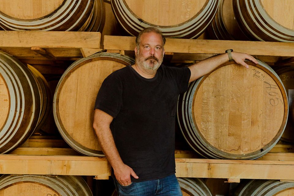 Alexander Stein stands in front of barrels