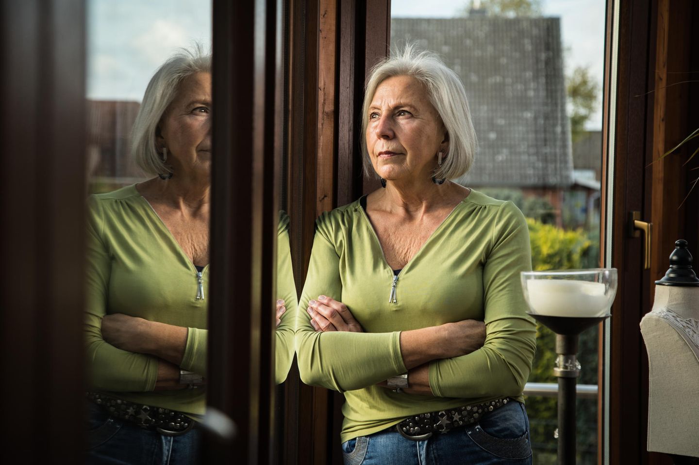 Eine Rentnerin schaut gedankenverloren aus dem Fenster