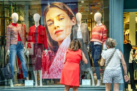 Zwei Frauen stehen vor dem Schaufenster eines Modegeschäfts