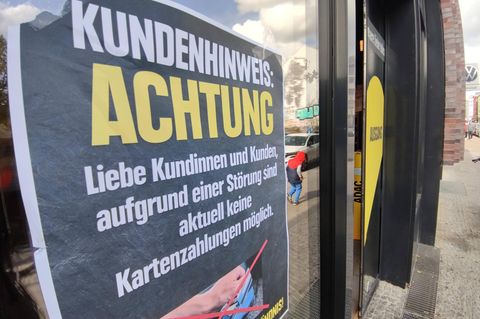 An einem Supermarkt hängt ein Schild, wonach die Kartenzahlung gestört ist