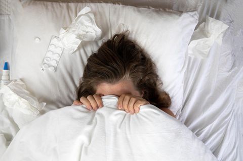 Lohnfortzahlung: Frau, krank im Bett