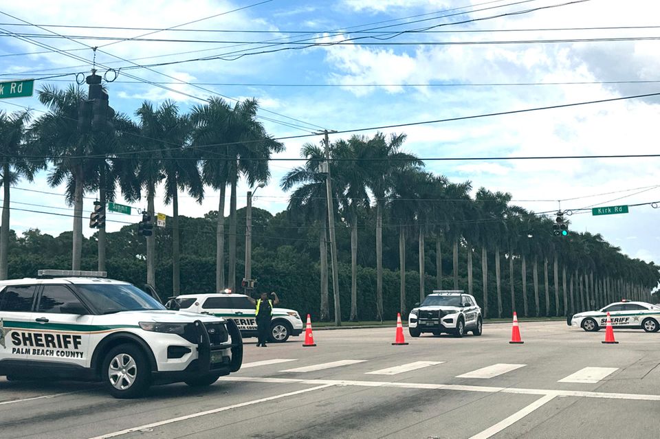 Polizisten haben in der Nähe des Golf Clubs von Donald Trump mit ihren Fahrzeugen eine Kreuzung gesperrt