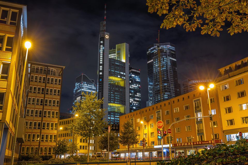 Wolken ziehen am dunklen Abendhimmel über den leuchtenden Commerzbank Tower hinweg