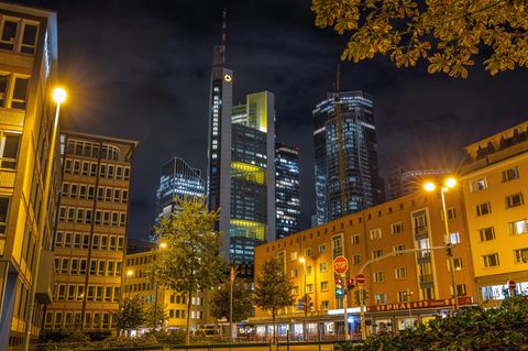 Wolken ziehen am dunklen Abendhimmel über den leuchtenden Commerzbank Tower hinweg