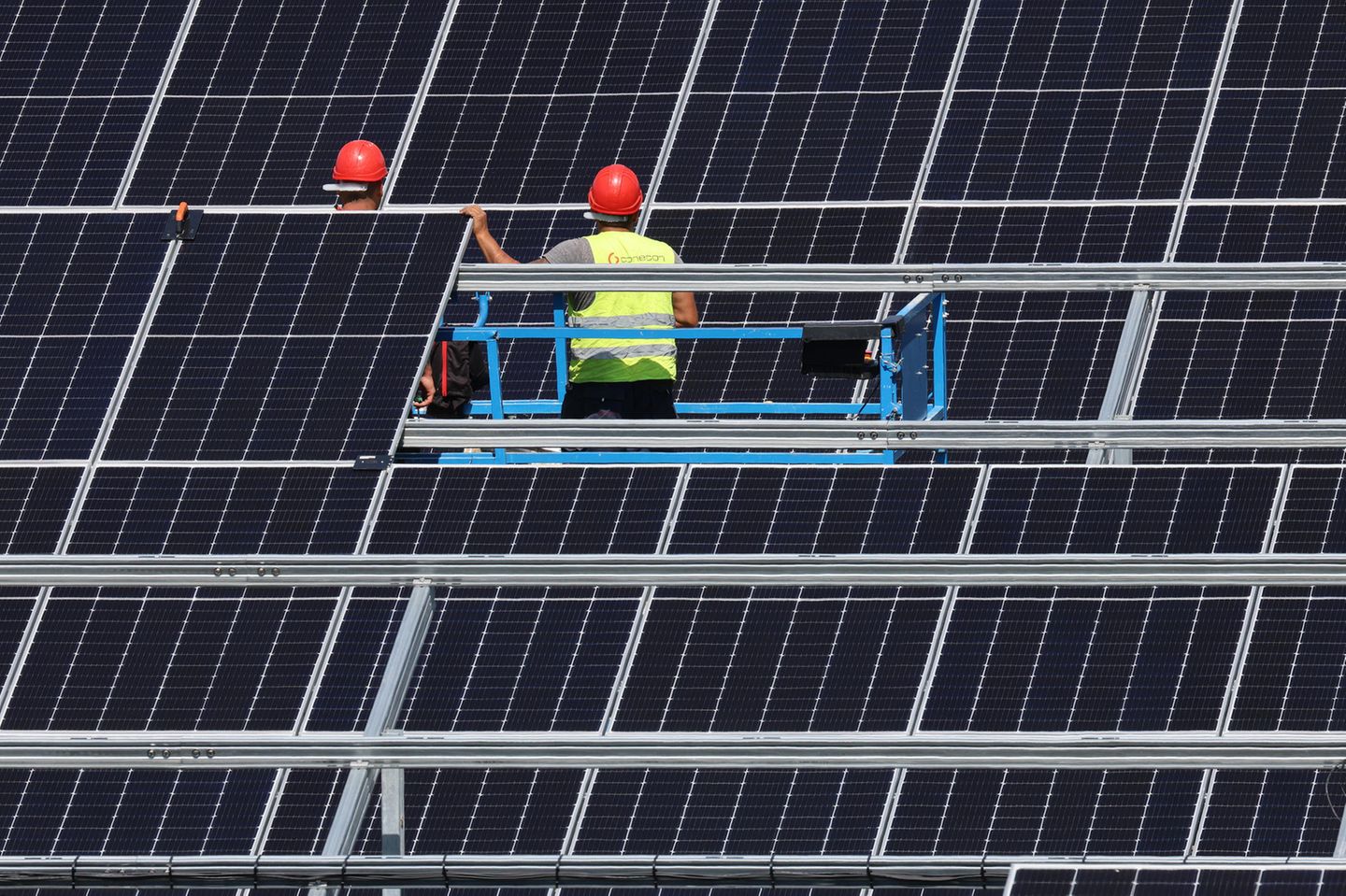 Mitarbeiter einer Montagefirma montieren Solarmodule im Solarpark in Langenenslingen