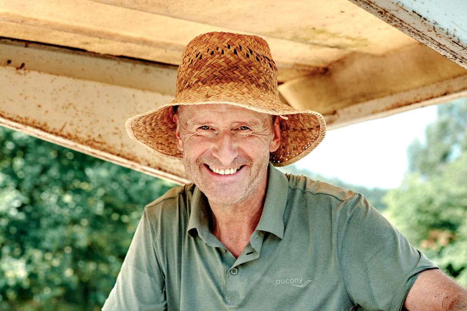 Former VW boss Herbert Diess sits on a tractor