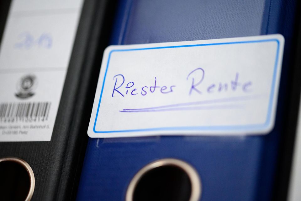 Ein Ordner mit einem Aufkleber „Riester-Rente“ steht in einem Regal.