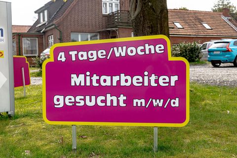Ein Schild mit der Aufschrift „4 Tage/Woche, Mitarbeiter gesucht m/w/d“ steht am Straßenrand