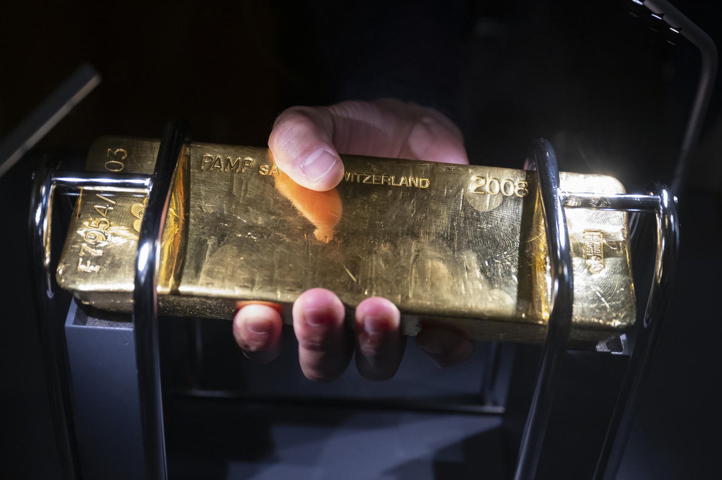 Ein Besucher der Schweizerischen Nationalbank hält einen Goldbarren in den Händen