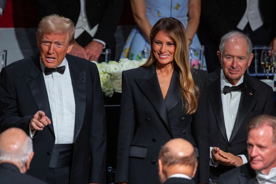 Donald Trump (l.) steht neben seiner Frau Melania und Stephen Schwarzman