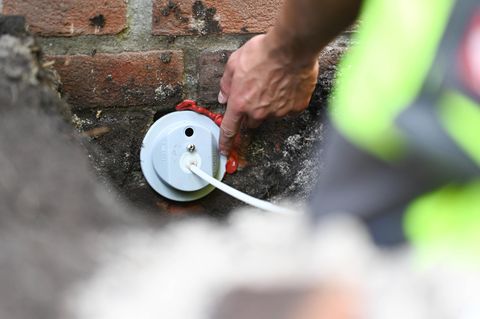 Glasfaser-Ausbau: Mitarbeiter installierten einen Glasfaser-Hausanschluss