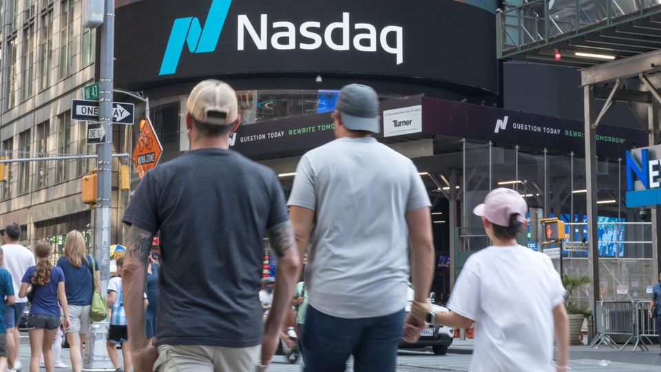 Menschen laufen an der Nasdaq-Börse in New York am Times Square vorbei