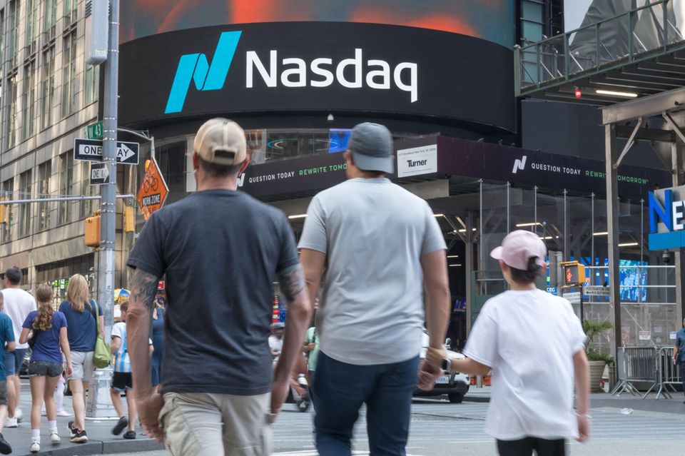 Menschen laufen an der Nasdaq-Börse in New York am Times Square vorbei
