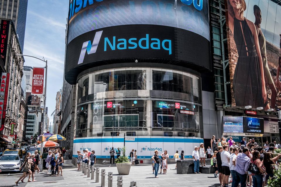 Menschen strömen entlang des Nasdaq-Gebäudes am Times Square in New York