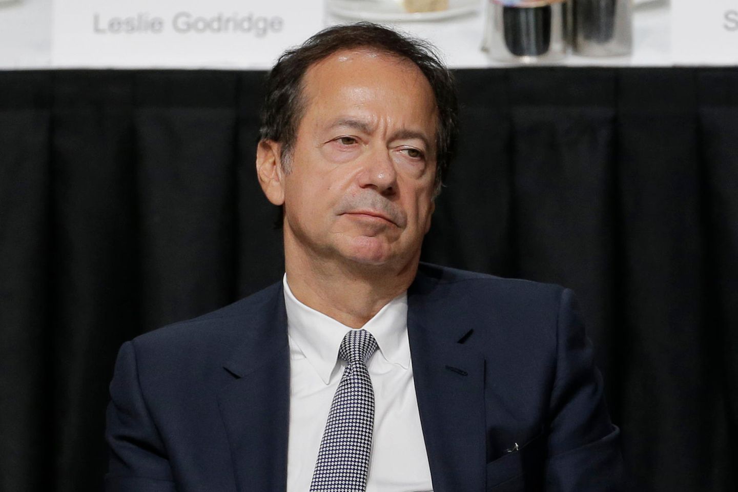 John Paulson hört einer Rede Trumps zu