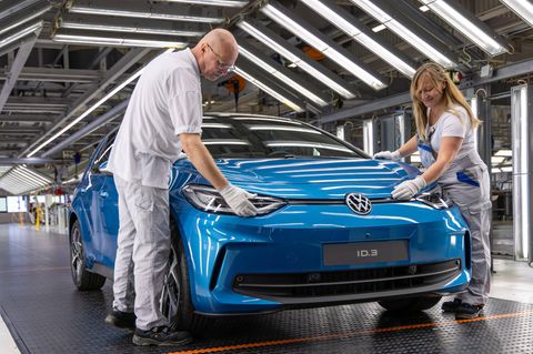 Ein VW-Mitarbeiter und eine VW-Mitarbeiterin montieren einen ID3