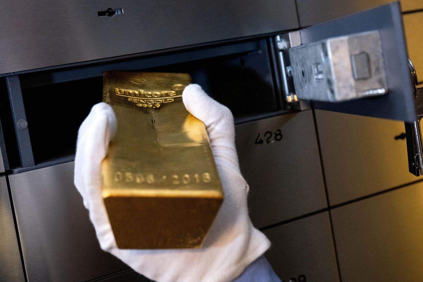 Ein Mann legt beim Edelmetallhändler Pro Aurum einen Goldbarren in ein Schließfach in einem Tresorraum