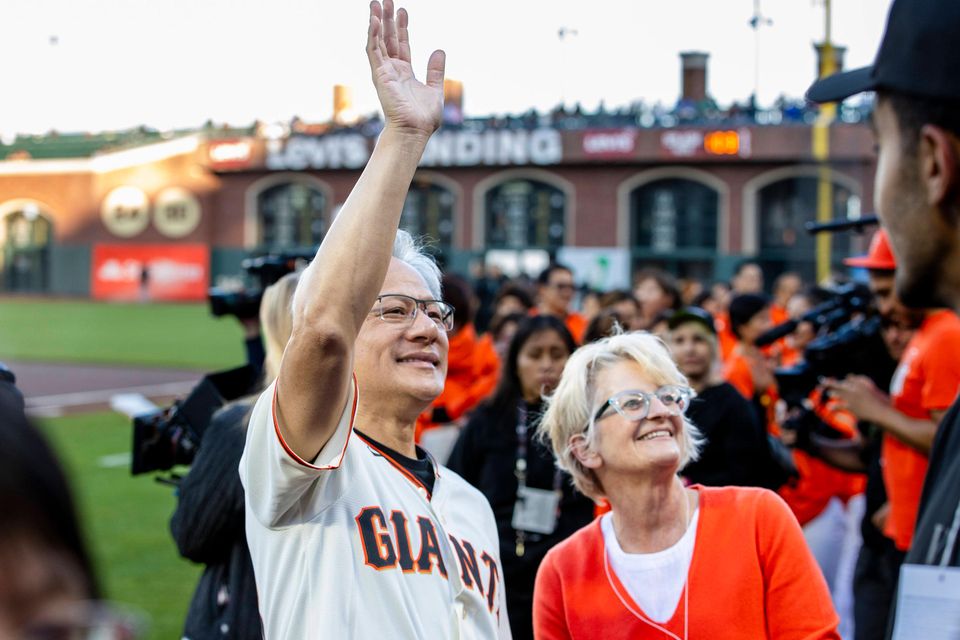Nvidia CEO Jensen Huang winkt der Menge bei einem Baseball-Spiel zu