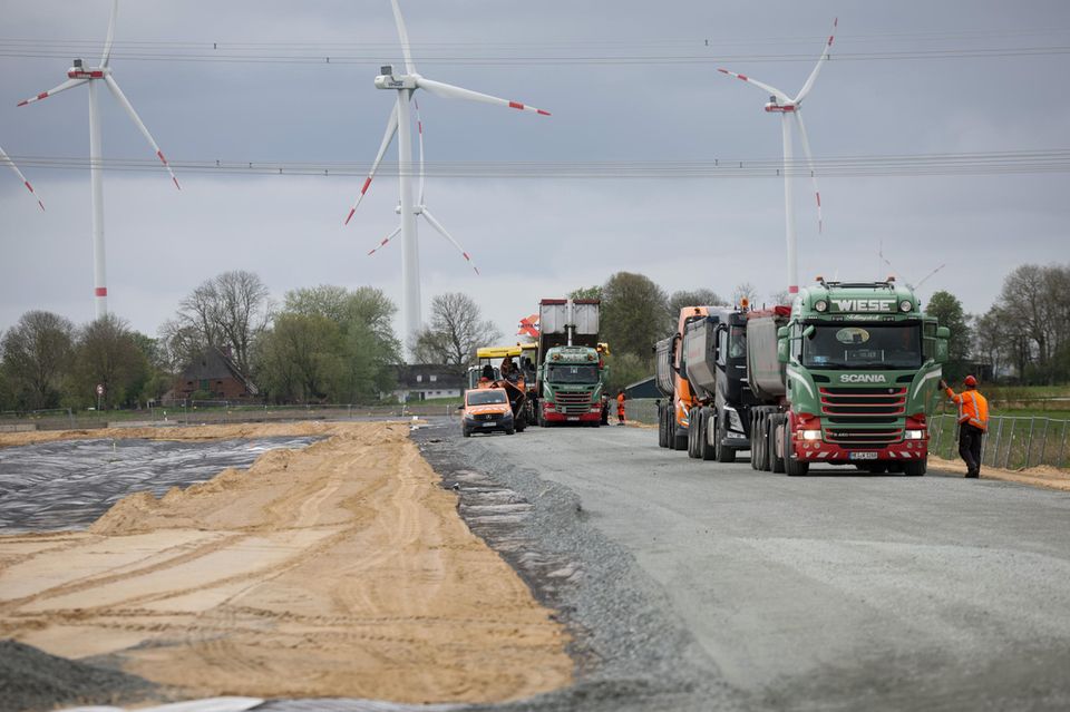Baustellenfahrzeuge sind bei Asphaltarbeiten auf dem künftigen Northvolt-Gelände in Heide tätig