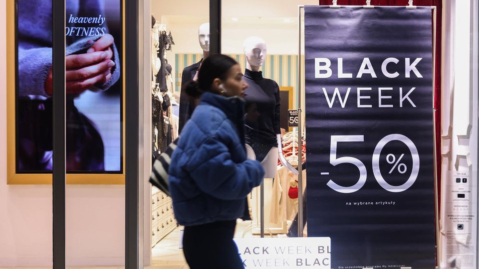 Frau läuft an einem Black Week Poster vorbei