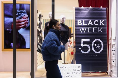 Frau läuft an einem Black Week Poster vorbei