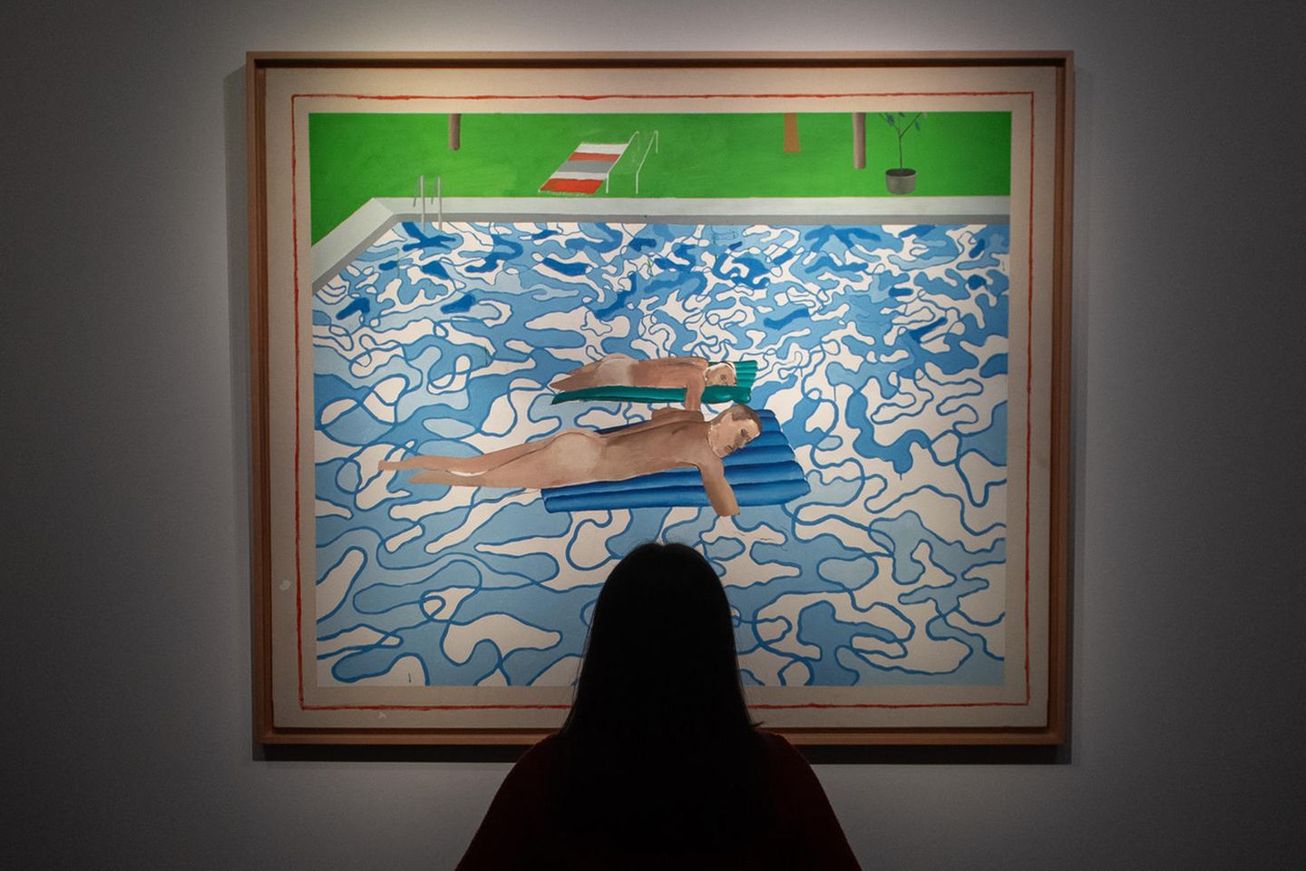 Eine Frau betrachtet ein Bild von David Hockney
