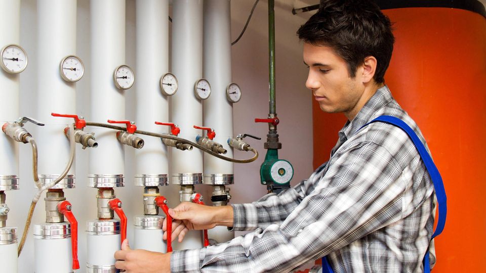 Heizungstechniker wartet eine Heizanlage Heizungstechniker wartet eine Heizanlage