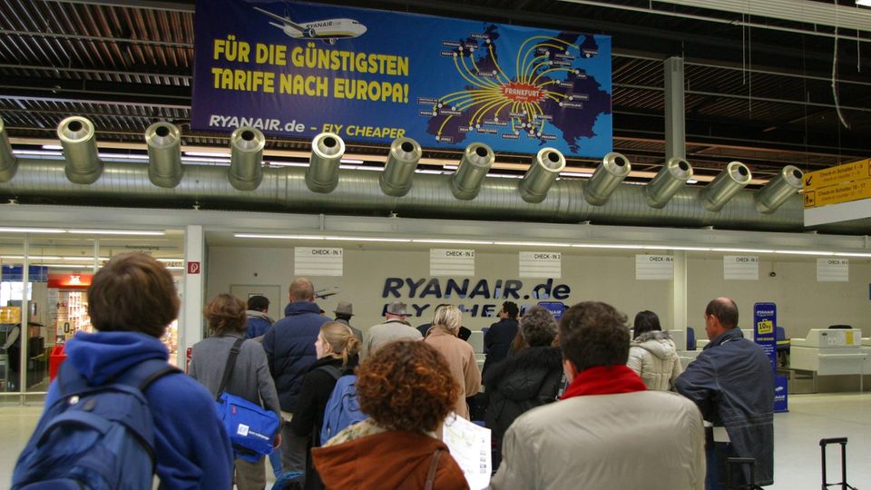 Fluggäste warten am Check-In von Ryanair im Flughafen Frankfurt-Hahn