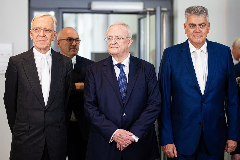 Martin Winterkorn steht zwischen seinen Verteidigern