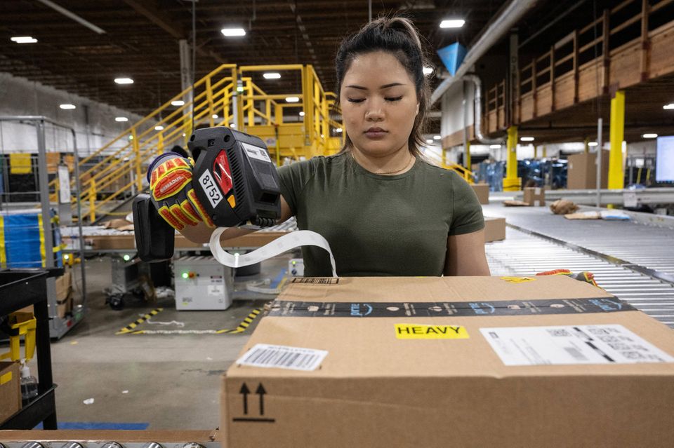 Frau markiert Pakete in der Amazon Delivery Station