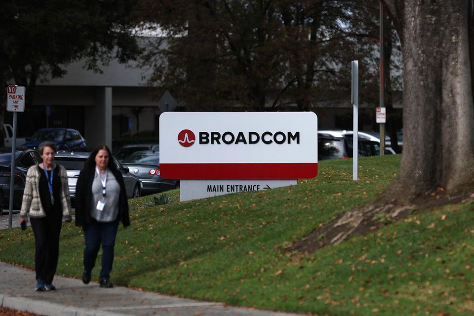 Zwei Frauen gehen an einem Broadcom-Schild vor der Unternehmenszentrale in San Jose vorbei