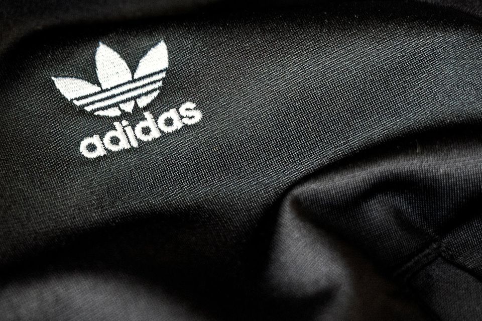 Das Adidas-Logo ist auf ein schwarzes, recyceltes Polyestergewebe genäht