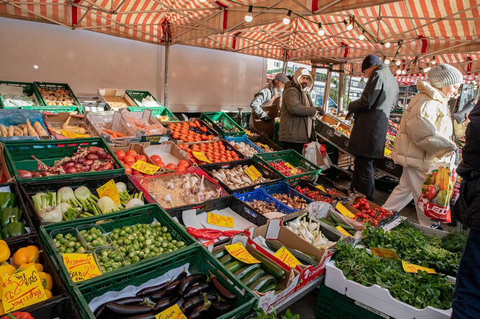 Menschen kaufen auf einem Gemüsemarkt in Berlin ein