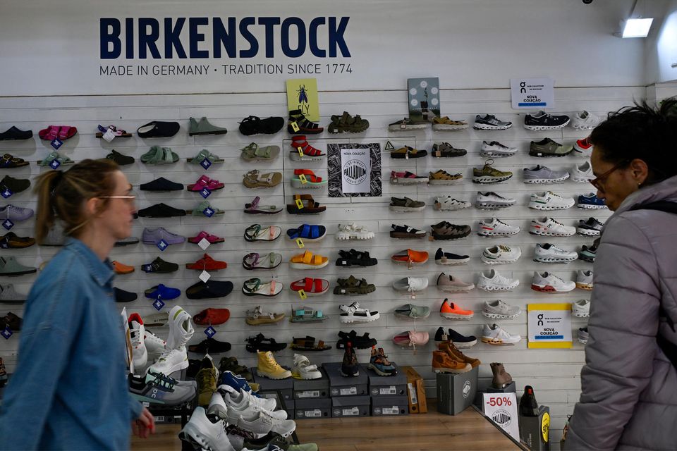 Eine Frau geht an einem Birkenstock-Geschäft vorbei