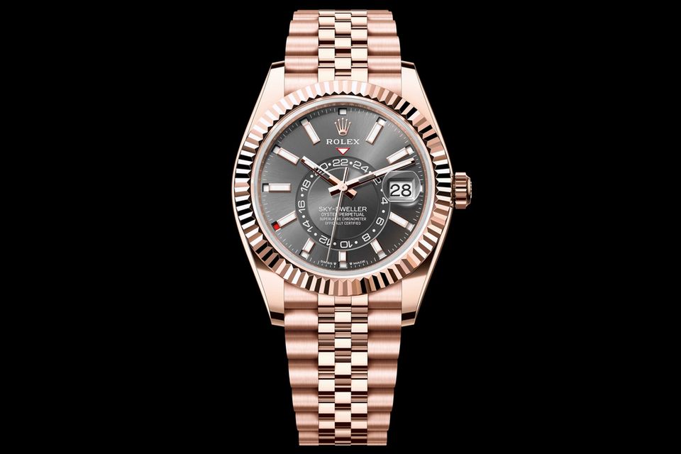 Oyster Perpetual Sky-Dweller     WAS DIESE UHR BESONDERS AUSZEICHNET: Allein die Mischung aus „Everose“-Goldfür Gehäuse und das dreigliedrige Oyster-Band sowie Schiefergrau für das Zifferblatt mitSonnenschliff macht dieses Modell zu einem Hingucker. Die Heimatzeit ihres Besitzers wird auf einer inneren Scheibe angezeigt und von einem roten Dreieck markiert. Dank einer 24-Stunden-Nummerierung besteht nie Zweifel über Tag oder Nacht. Ein rotes Rechteck an der Spitze der zwölf Indexe verweist auf den aktuellen Monat.     BASISDATEN (AUSZUG): Kaliber 9002 (Werk), COSC- und Rolex-zertifiziert, 18 Karat„Everose“-Gold (Gehäuse), 42 mm Durchmesser, wasserdicht bis 100 m, 72 Stunden Gangreserve.     PREIS: 55.100 Euro