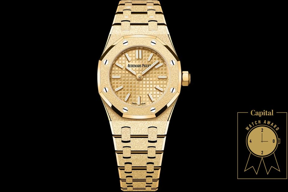 Royal Oak Mini Frosted Gold Quarz     WAS DIESE UHR BESONDERS AUSZEICHNET: Als die „Mini Royal Oak“ anno 1997 lanciert wurde, betrug ihr Durchmesser gerade mal 20 Millimeter und bediente den Zeitgeist, der nach sportlicher Eleganz verlangte. Diese leicht vergrößerte Neuinterpretation ist mit einem Manufaktur-Quarzwerk ausgestattet und in drei Farbnuancen erhältlich. Die wie vereist wirkende Oberfläche wird mit einer Handwerkstechnik florentinischer Goldschmiede herausgearbeitet. Das Zifferblatt weist das markentypische „Petite Tapisserie“-Muster auf.     BASISDATEN (AUSZUG): Quarzwerk 2730 (Werk), 18 Karat Gelbgold (Gehäuse), 23 mm Durchmesser, wasserdicht bis 50 m.     PREIS: 34.000 Euro