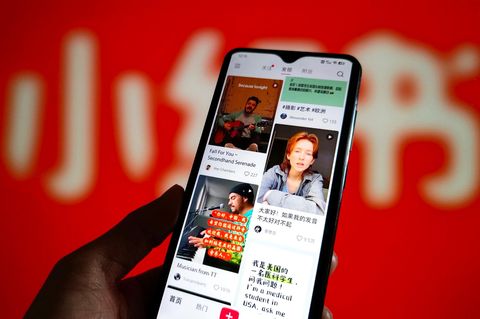 Eine Hand hält ein Smartphone, auf dem der Feed der Tiktok-Alternative Rednote gezeigt wird