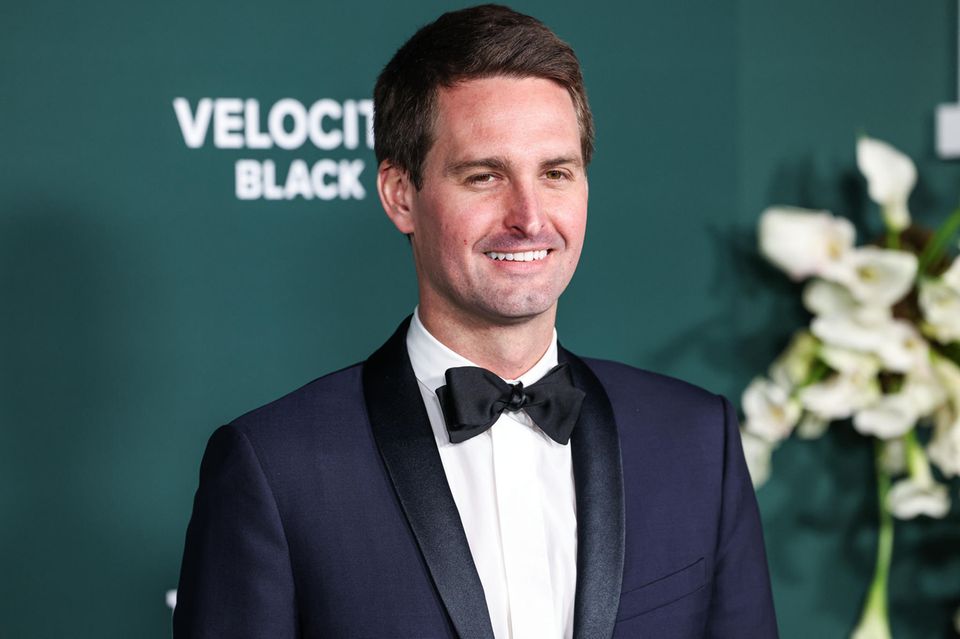 Snapchat-CEO Evan Spiegel steht im Smoking vor einer grünen Wand.